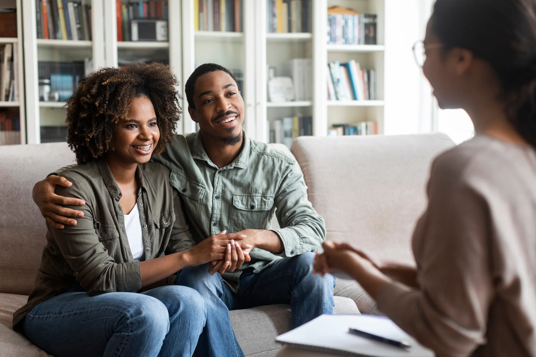 A couple sitting close together on a sofa during a counseling session